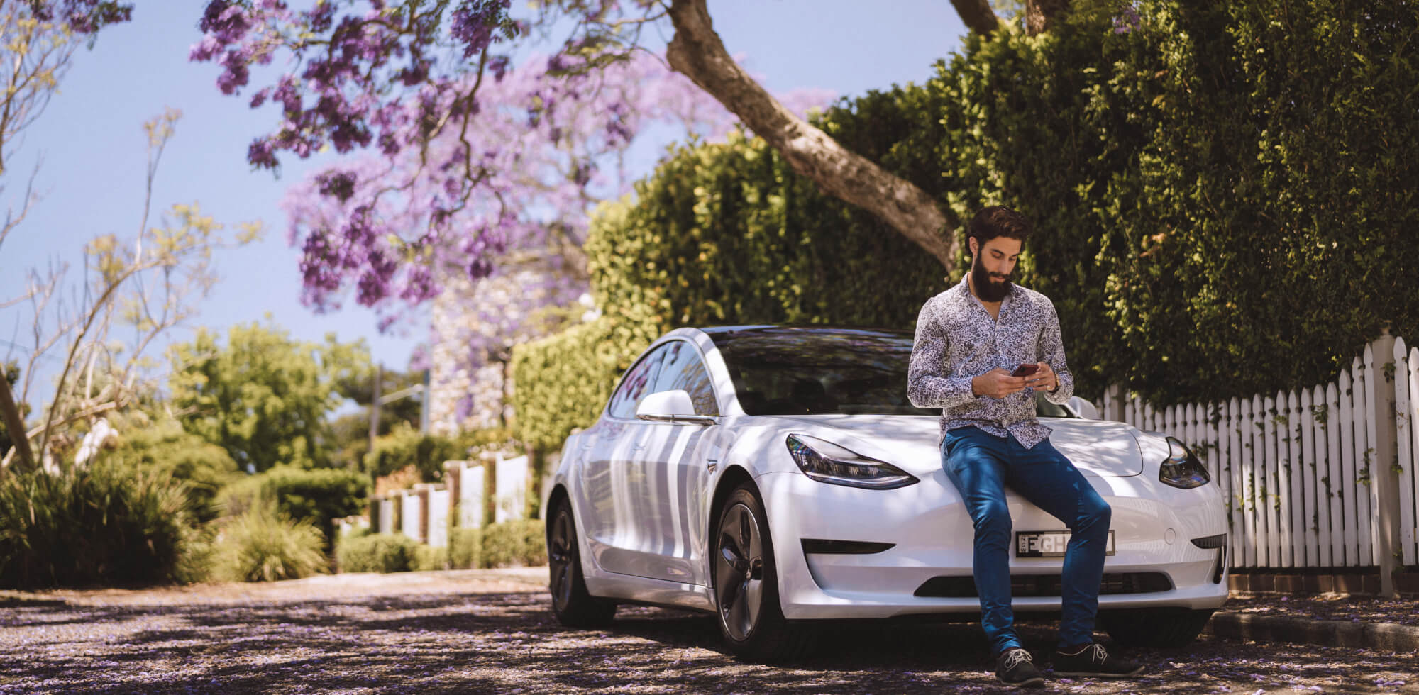 Sports car man on phone suburban street view