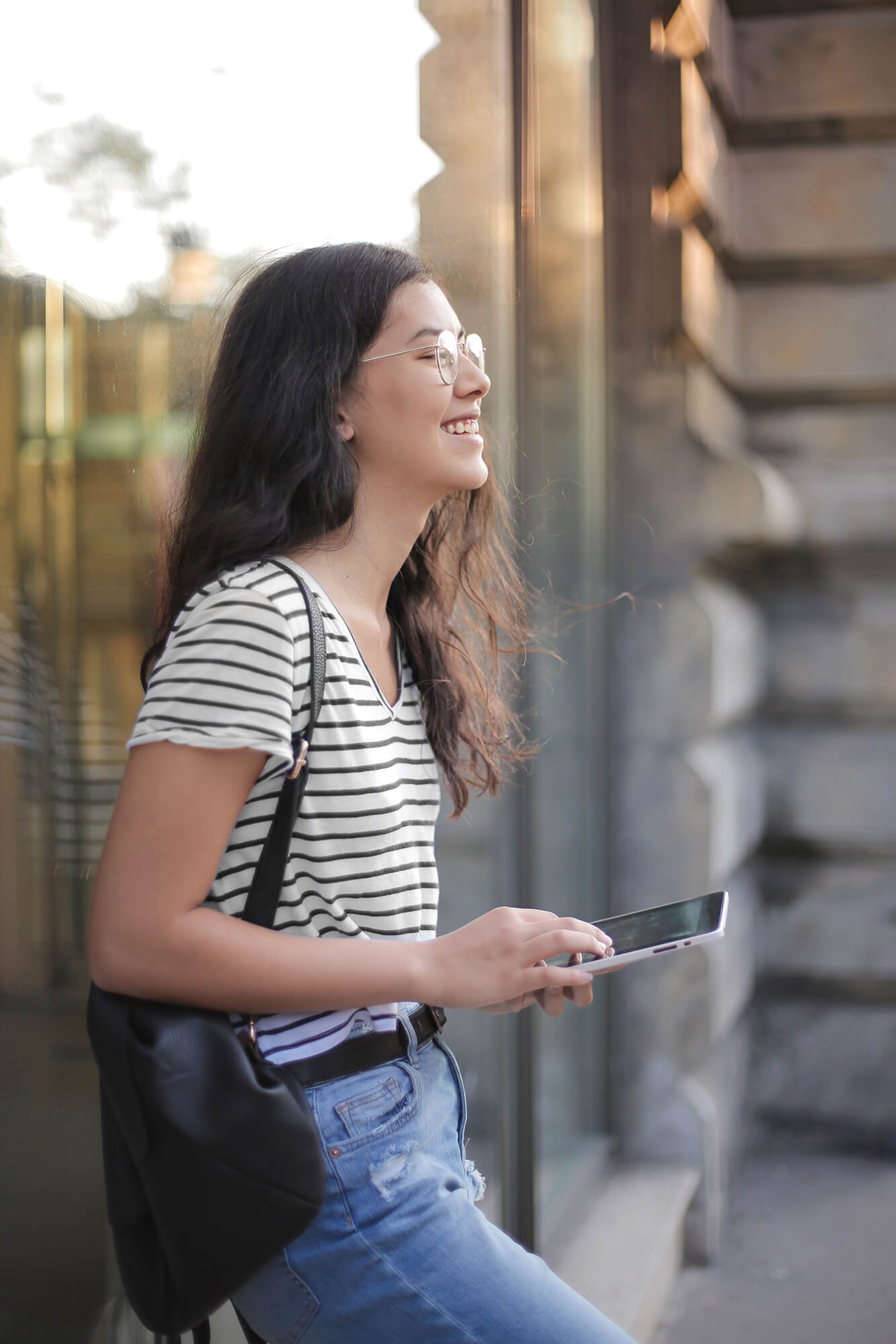 girl with striped shirt on tablet outside 